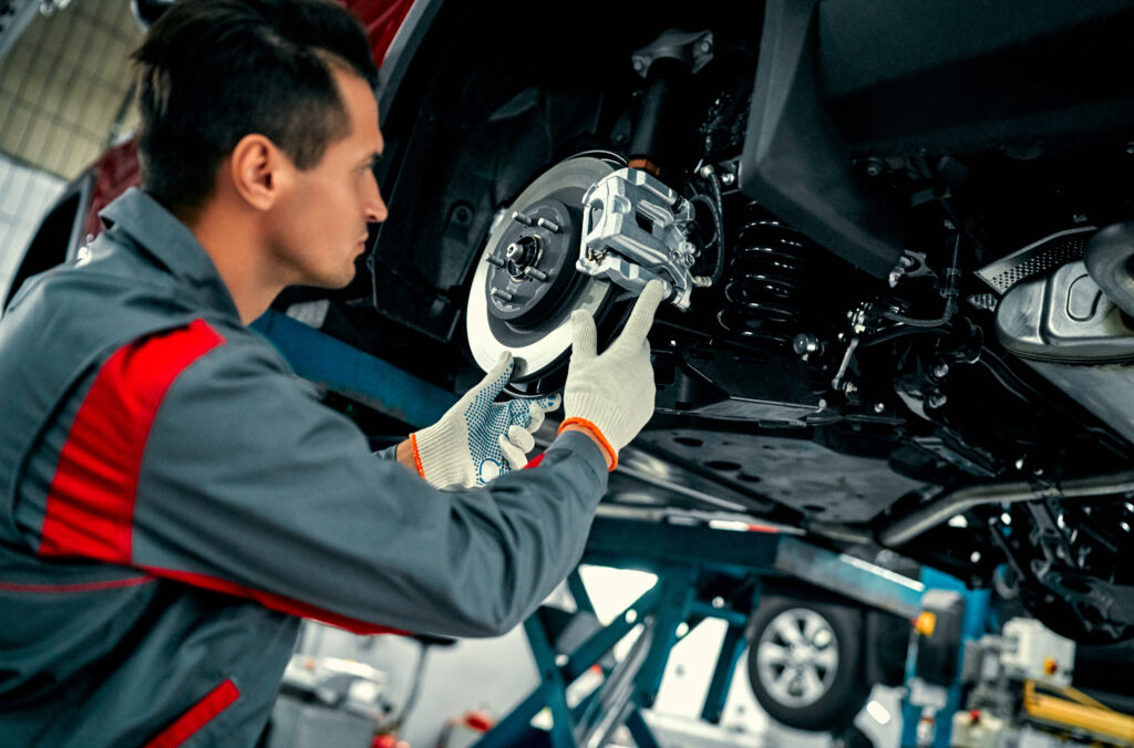 Car mechanic working on break disk