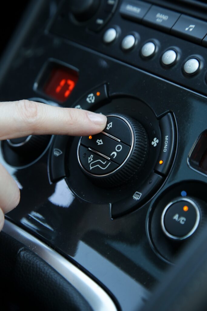 Hand adjusting the air conditioner in the car